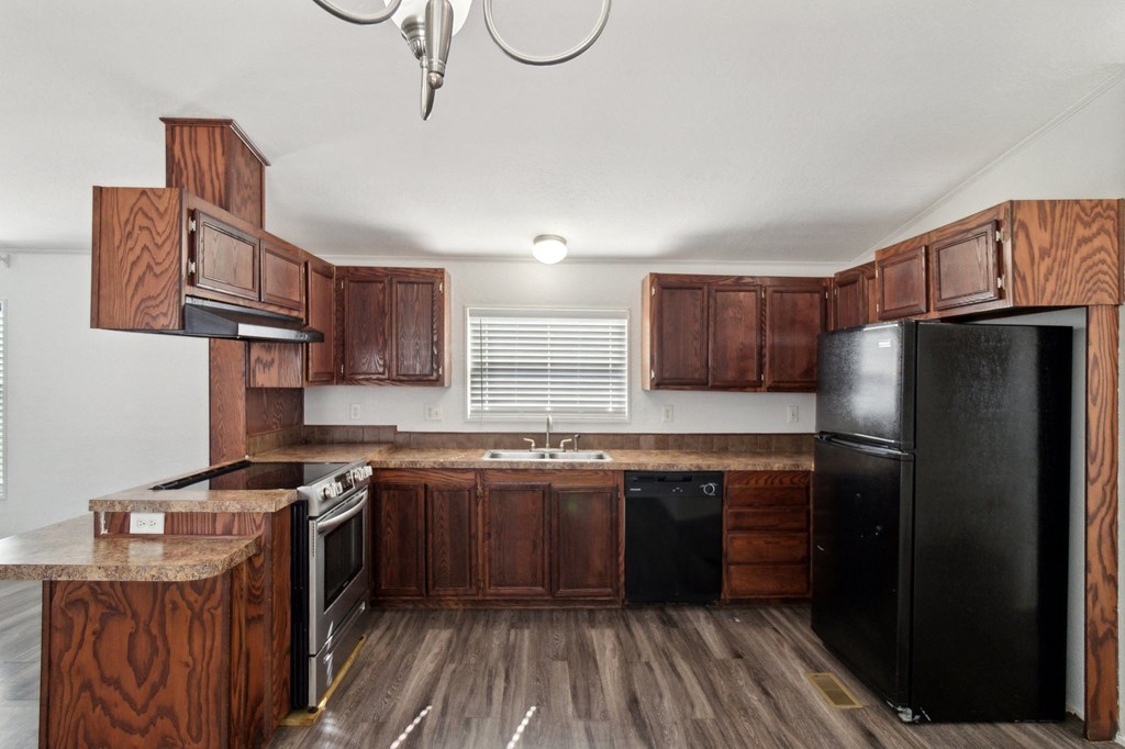 A kitchen with wooden cabinets and black appliances.