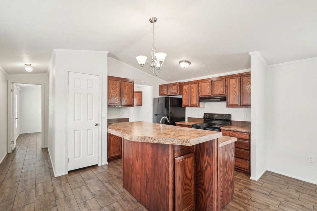 A kitchen with wooden cabinets and a granite countertop.