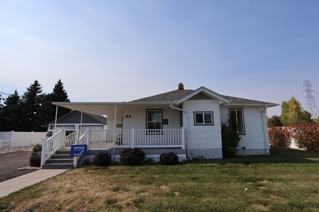 a white house with a porch and a lawn at Country Lane, Cheyenne, 82007