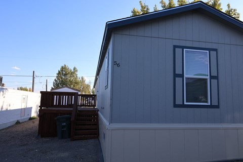 the exterior of a tiny house with a deck and a window at Horizon MHC, Rock Springs, Wyoming