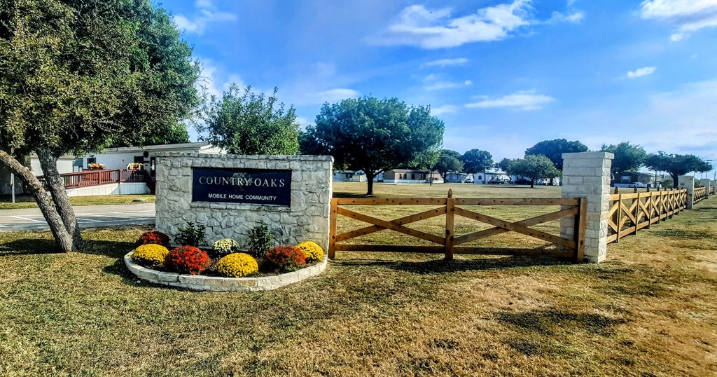 The entrance to Country Oaks Golf Course is marked by a sign and a wooden gate.