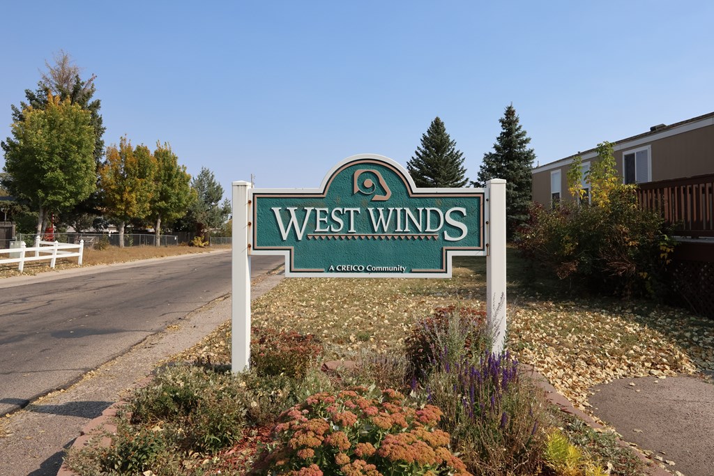 A sign that says West Winds in front of a building.