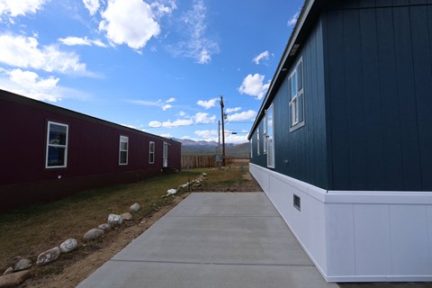 a view of the side of a house with a sidewalk in front of it