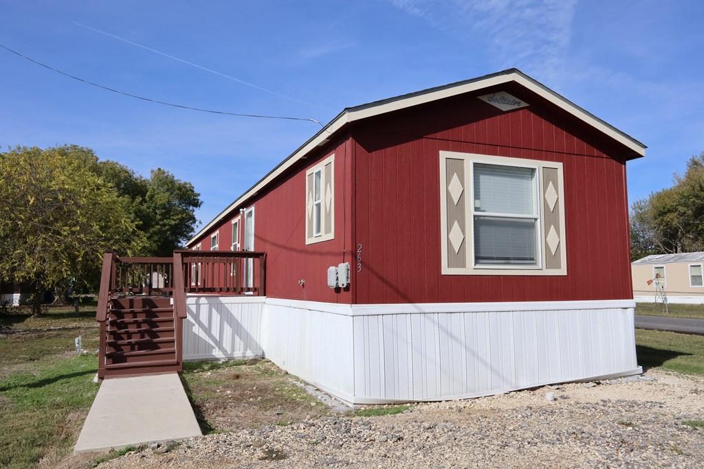 A red house with a white fence and a brown staircase.