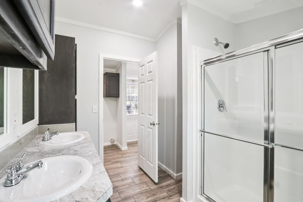 A bathroom with a walk-in shower and double sinks.