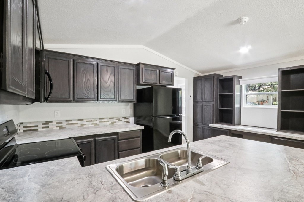 A kitchen with a sink and a stove top oven.