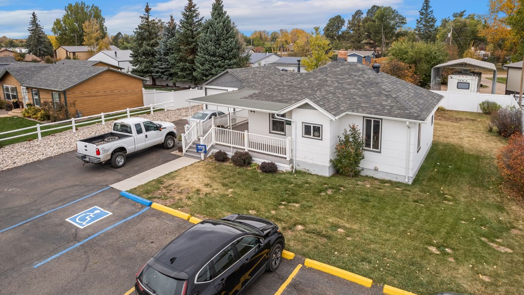 a white house with a car parked in a parking lot at Country Lane, Wyoming, 82007