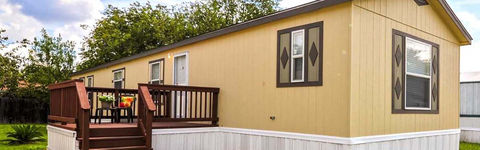 a yellow house with a deck with two chairs