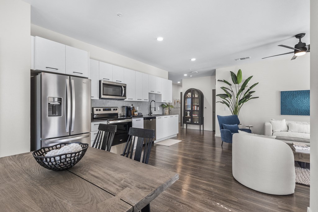 a kitchen and living room with stainless steel appliances and a table