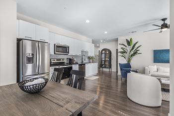 a kitchen and living room with stainless steel appliances and a table