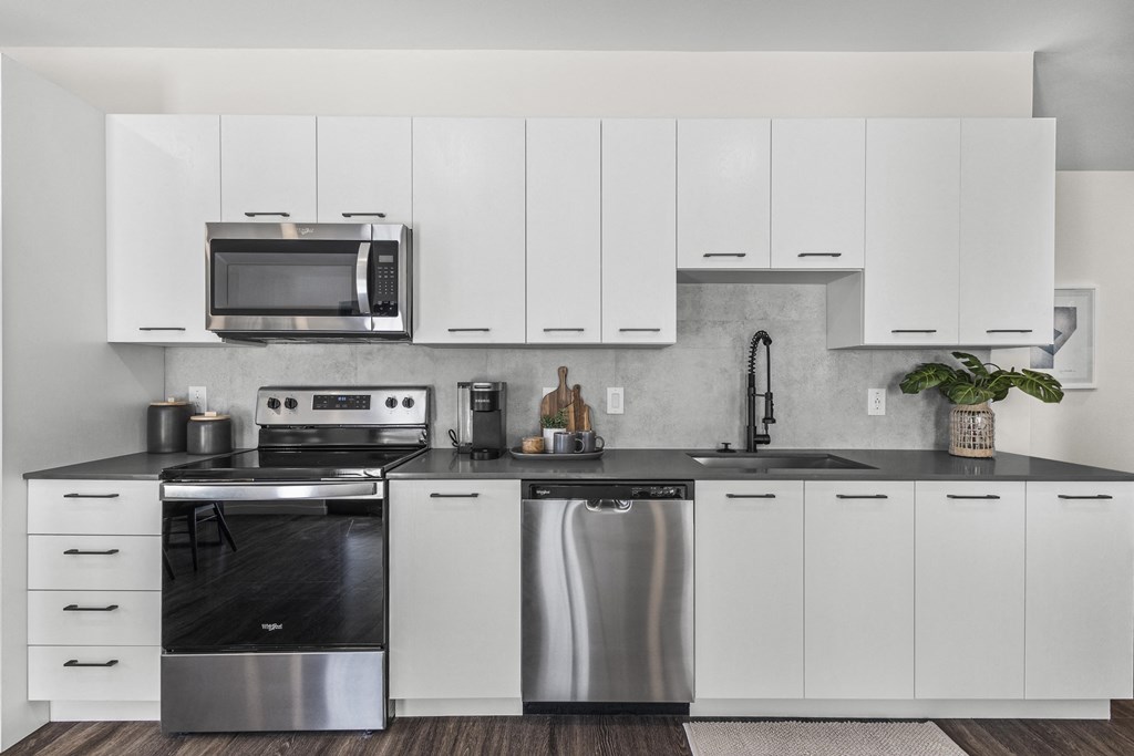 a white kitchen with stainless steel appliances and white cabinets