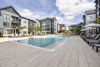 a swimming pool in front of a row of apartment buildings