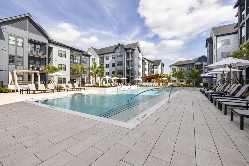 a swimming pool in front of a row of apartment buildings