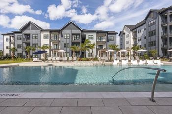 a swimming pool with an apartment building in the background