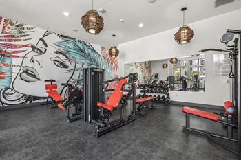 a fitness room with graffiti on the wall and exercise machines