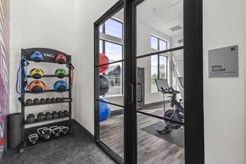 a workout room with weights and a treadmill and a window