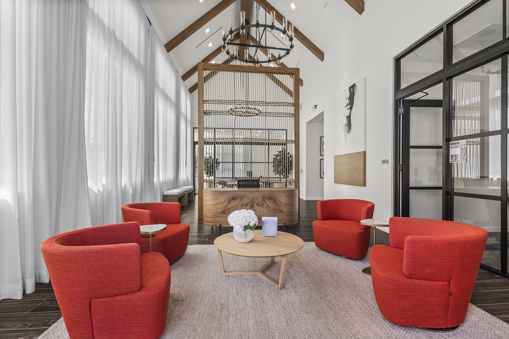 a living room with red chairs and a table