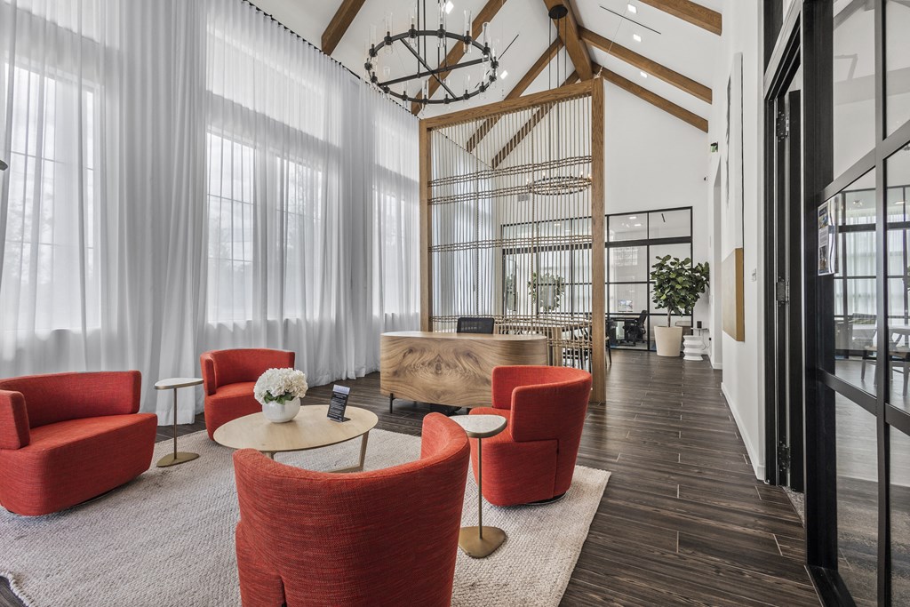 the lobby of a hotel with red chairs and a coffee table