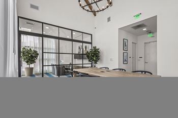 a dining room with a large wooden table and glass doors