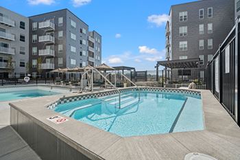 a swimming pool with two apartment buildings in the background