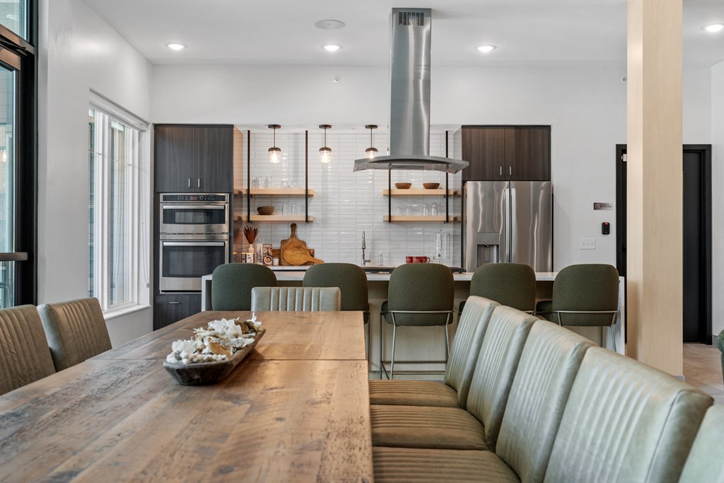 a kitchen and dining area with a wooden table and grey chairs at The Lodge at Overland, Minnesota, 55901