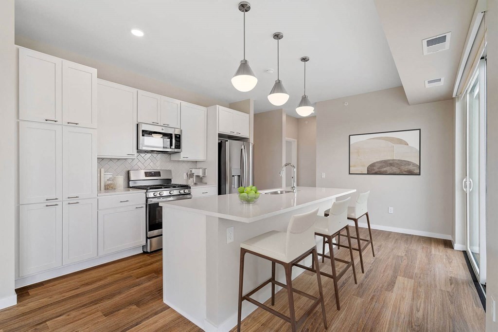 modern eat-in kitchen with island and stainless steel appliances at The Hallon Apartments, Hopkins