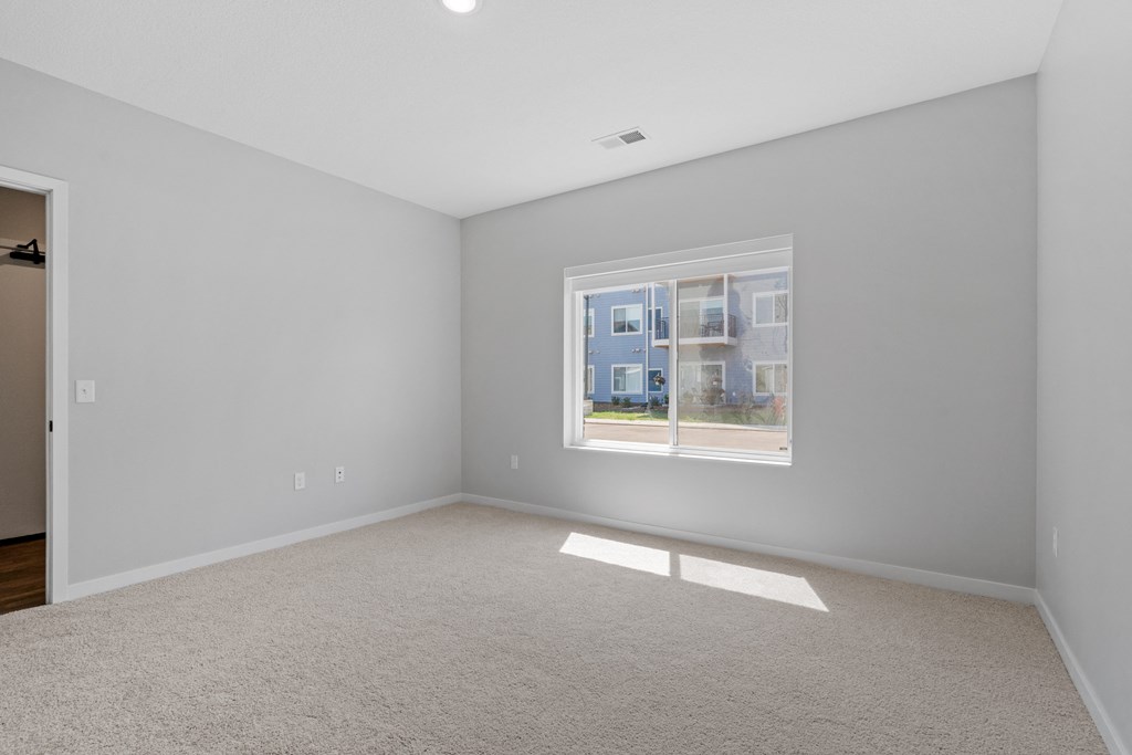 a bedroom with a large window at The Lodge at Overland, Rochester, MN