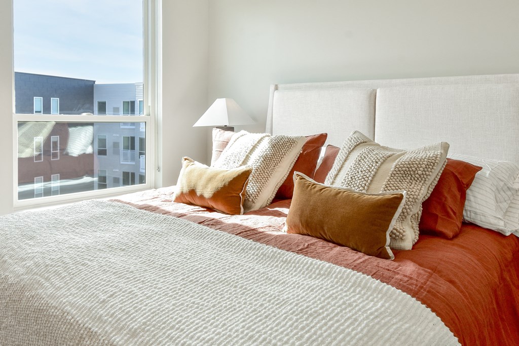 a bedroom with a large bed with pillows and a window at The Hallon Apartments, Hopkins