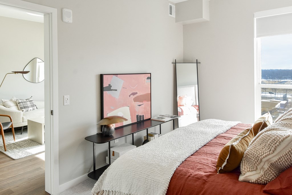 a bedroom with a bed and a desk with a mirror at The Hallon Apartments, Minnesota, 55343