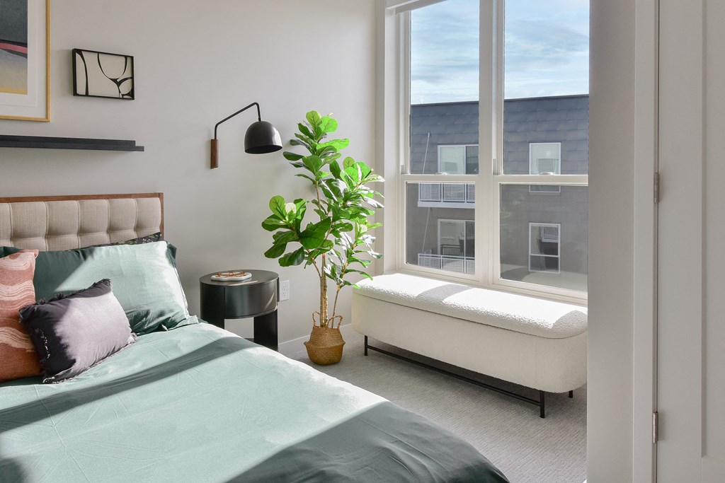 a bedroom with a bed and a large window at The Hallon Apartments, Minnesota