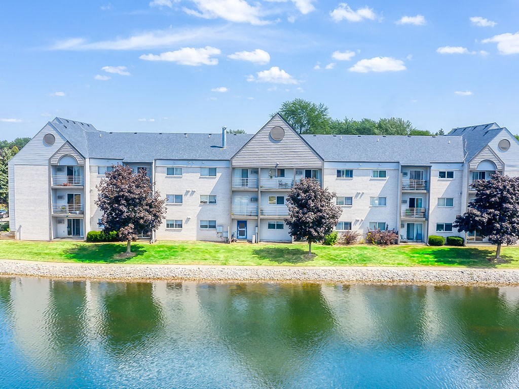 Lush landscaping with lake at Waterchase Apartments in Wyoming, MI