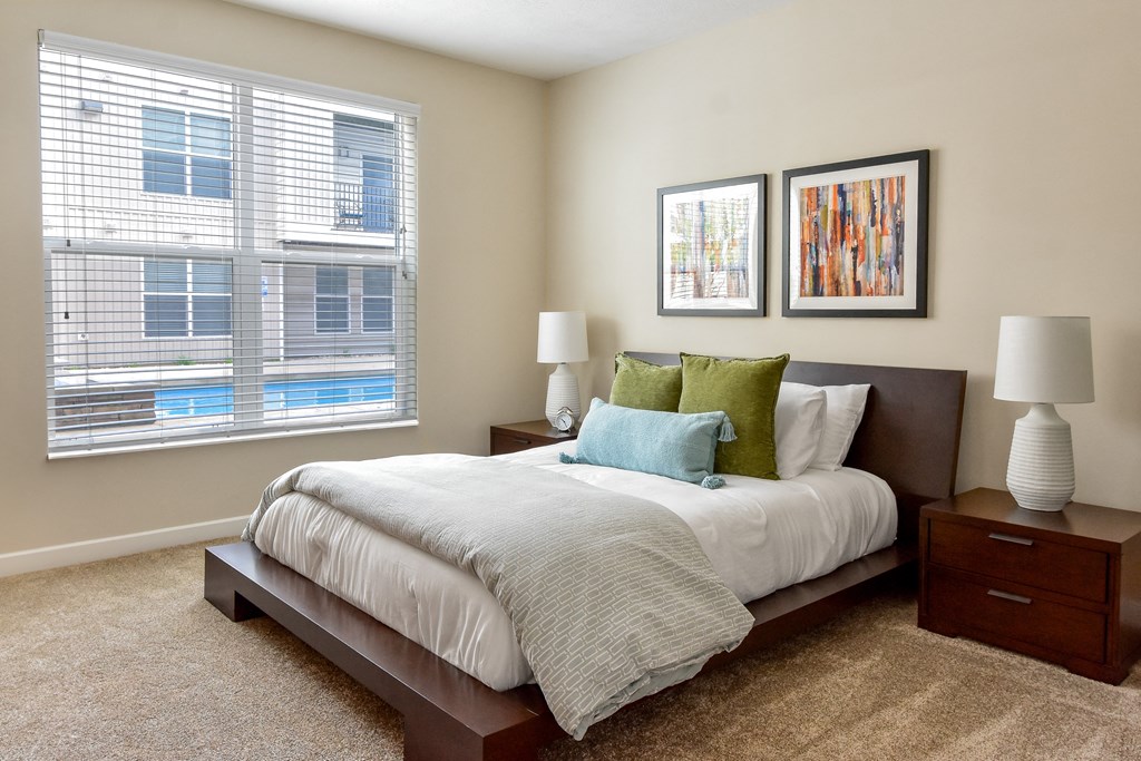 Westerville, OH Apartments Near Target - Kenyon Square - Furnished Bedroom with Plush Carpet Flooring, 9’ Ceiling, and an Oversized Window with Blinds Westerville, OH Apartments Near Target - Kenyon Square - Furnished Bedroom with Plush Carpet Flooring, 9’ Ceiling, and an Oversized Window with Blinds
