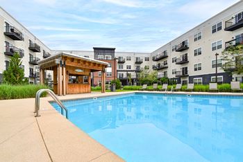 a swimming pool with an apartment building in the background
