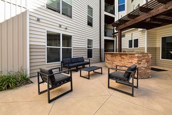 A patio with two black chairs and a table.