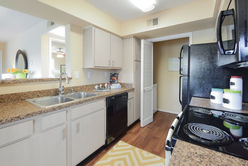 a kitchen with white cabinets and black appliances