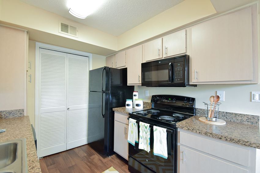 a kitchen with white cabinets and black appliances