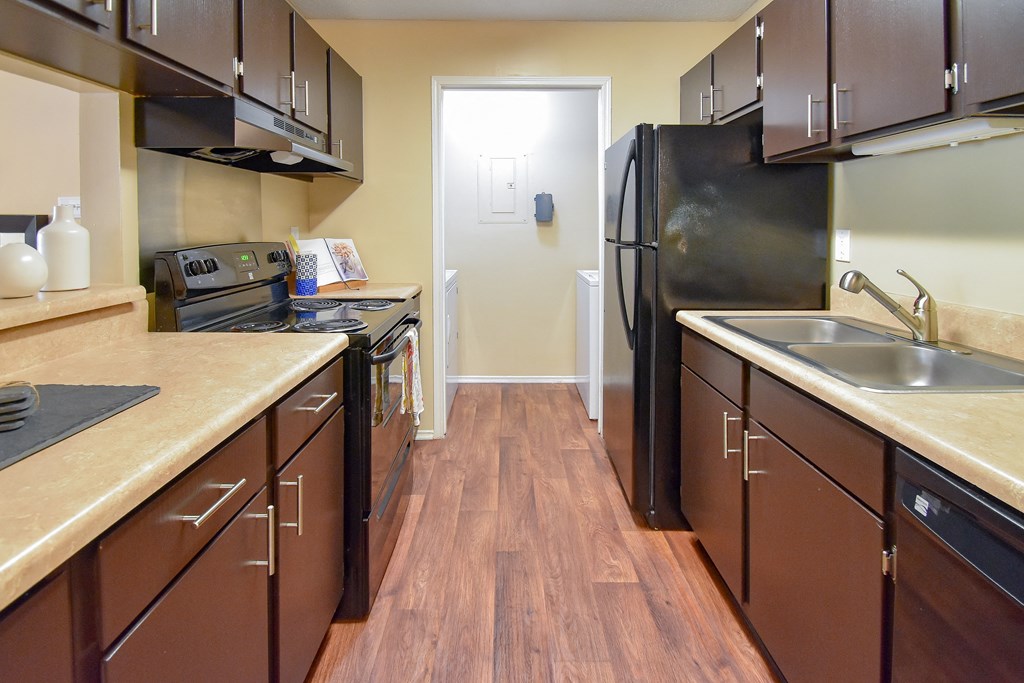 a kitchen with a black refrigerator freezer next to a stove top oven  at Riverset Apartments, Tennessee