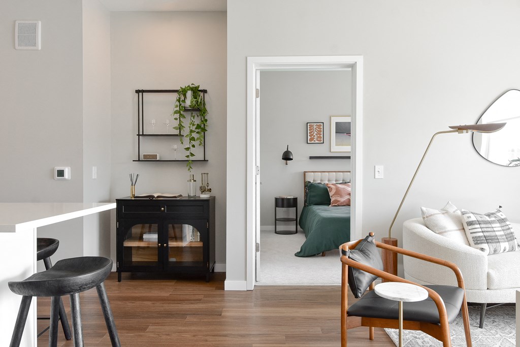 a living room with a couch and a chair and a bedroom with a bed at The Hallon Apartments, Minnesota, 55343