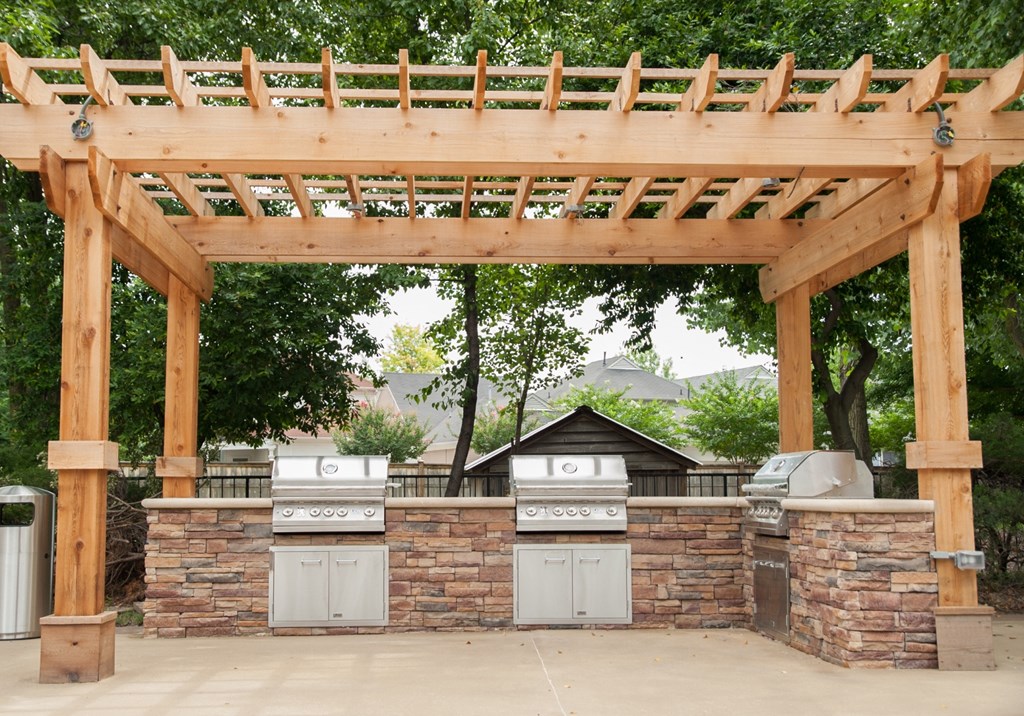 an outdoor kitchen with a pergola and barbecue  at Riverset Apartments, Tennessee, 38103