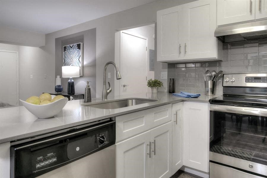 Ann Arbor, MI Apartments for Rent - Villas at Northstar - Kitchen with White Cabinetry, Stainless Steel Appliances, Grey Tile Backsplash, and Grey Counters Ann Arbor, MI Apartments for Rent - Villas at Northstar - Kitchen with White Cabinetry, Stainless Steel Appliances, Grey Tile Backsplash, and Grey Counters