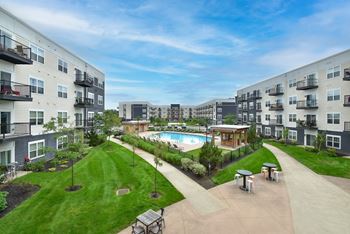 a view of an apartment complex with a pool and grassy area