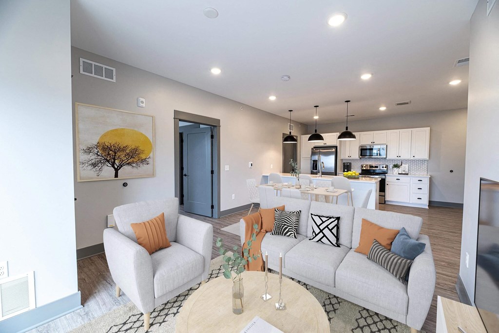 a living room and kitchen with couches and a table at The Commons at Rivertown, Grandville, MI