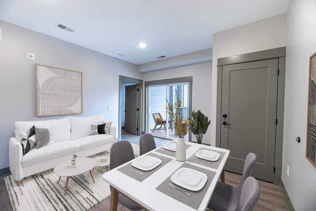 a living room with a white couch and a dining table at The Commons at Rivertown, Grandville, MI, 49418