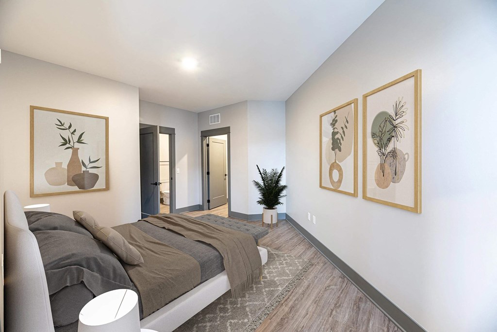 a bedroom with a bed and two paintings on the wall at The Commons at Rivertown, Grandville, MI, 49418