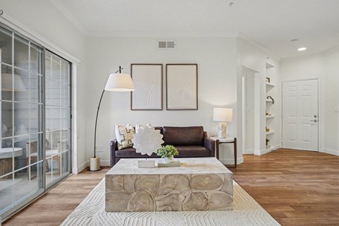 A living room with a brown couch and a wooden coffee table.