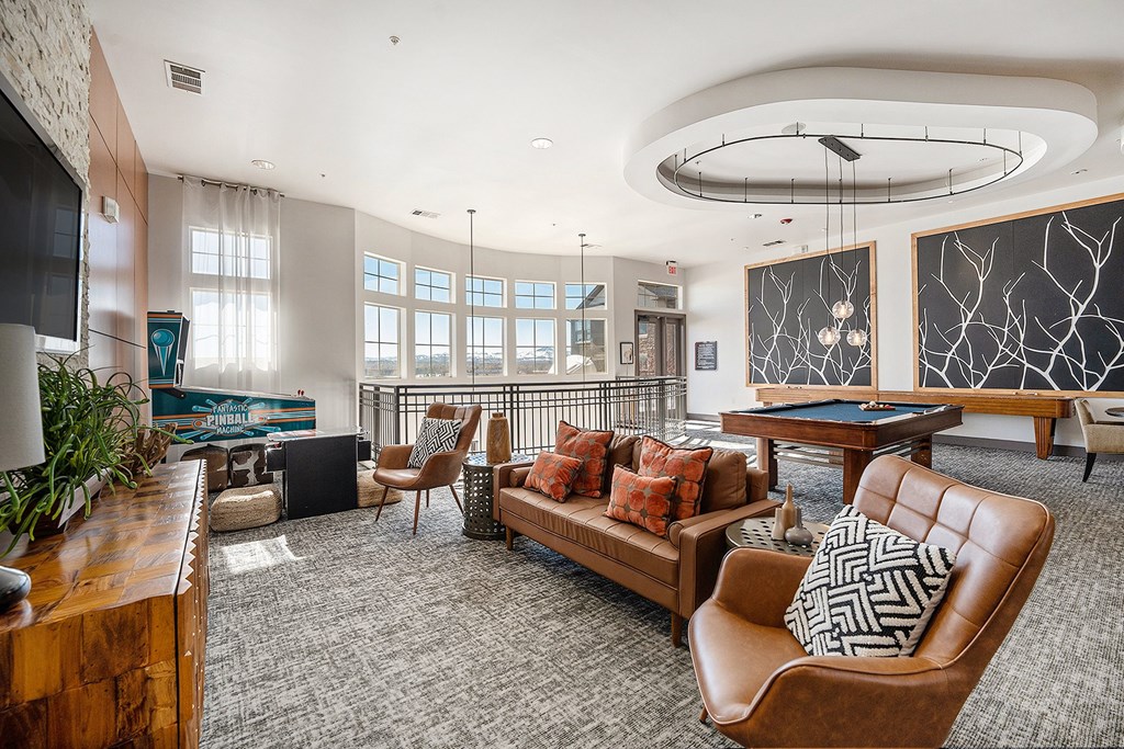 A living room with a pool table and a television.
