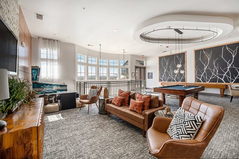 A living room with a pool table and a television.