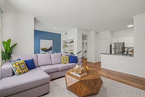 A living room with a grey couch and a wooden coffee table.