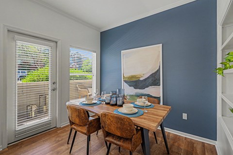A dining room with a wooden table set for two.
