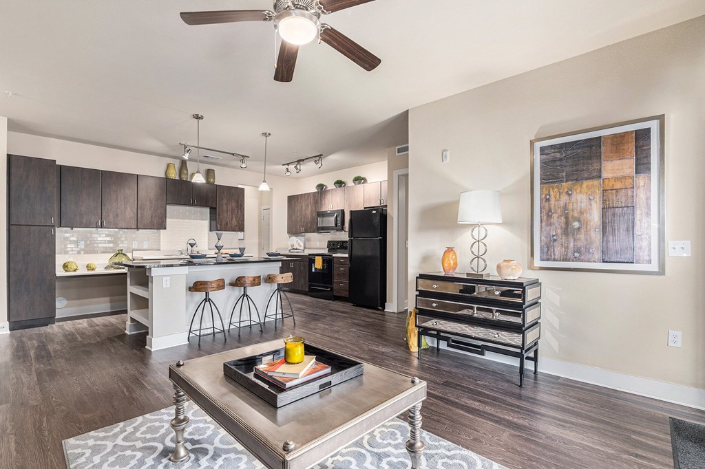 A modern kitchen with dark wood cabinets and a black fridge.